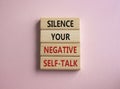 Silence your negative self-talk symbol. Concept words Silence your negative self-talk on wooden blocks. Beautiful pink background Royalty Free Stock Photo