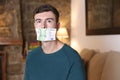 Silenced man with money covering mouth