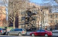 A Silent and Peacefool Neighborhood in Bronx, New York City. Parked Vehicles and Building With Fire Escape Ladders.