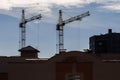 silhoette of tower cranes on construction site, providing housing for low-income citizens of third world countries