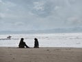 Silhoettes of mother, daughter and a serfer on a beach. Calm, peacefull atmosphere. Silverstrand, Sligo Ireland