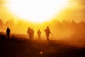 Silhouette action soldiers walking hold weapons the background is smoke and sunset and white balance ship effect dark Royalty Free Stock Photo