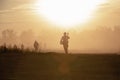 Silhouette action soldiers walking hold weapons the background is smoke and sunset and white balance ship effect dark Royalty Free Stock Photo