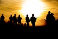 Silhouette action soldiers walking hold weapons the background is smoke and sunset and white balance ship effect dark Royalty Free Stock Photo