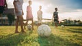 Silhouette action sport outdoors of diversity of kids having fun playing soccer football for exercise in community rural area unde