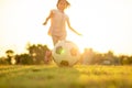 Silhouette action sport outdoors of diversity of kids having fun playing soccer football for exercise in community rural area unde