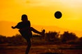 Silhouette action sport outdoors of a group of kids having fun playing soccer football for exercise in community under