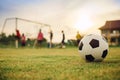 Silhouette action sport outdoors of a group of kids having fun playing soccer football for exercise in community under