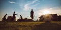 Silhouette action sport outdoors of kids having fun playing soccer football for exercise in community rural area under the twiligh