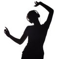 Silhouette of a active girl listening to music in headphones, figure of young woman dancing with hands up on a white isolated