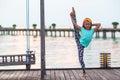 Silhouette of adorable little girl on wooden jetty