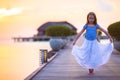 Silhouette of adorable little girl on wooden jetty