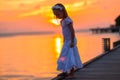 Silhouette of adorable little girl on wooden jetty