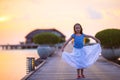 Silhouette of adorable little girl on wooden jetty