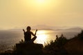 Silhouette adult woman practicing yoga near the sea at sunset. Royalty Free Stock Photo