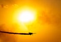 A silhouette of an aerobatic airplane flying at sunset against the crimson sky Royalty Free Stock Photo