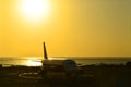 Silhouette of Aeroplane landing at Ngurah Rai International Airport during sunset time.