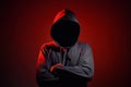 Silhouette af man without face in hood on red background. Anonymous crime concept Royalty Free Stock Photo