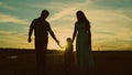 silhouette affectionate parents with child sunset. happy african family sunset park. mother father hold kid hands Royalty Free Stock Photo