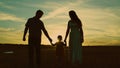 silhouette affectionate parents with child sunset. happy african family sunset park. mother father hold kid hands Royalty Free Stock Photo