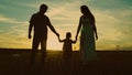 silhouette affectionate parents with child sunset. happy african family sunset park. mother father hold kid hands Royalty Free Stock Photo