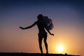 Silhouette of African girl on hill top posing and dancing with sunset view and ocean view.