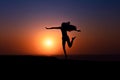 Silhouette of African girl on hill top posing and dancing with sunset view and ocean view. Royalty Free Stock Photo