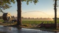 Silhouette of agricultural irrigation system watering cornfield at sunset. Cornfield irrigation using the center pivot sprinkler Royalty Free Stock Photo