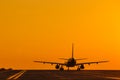 Silhouette of air plane landing at sunset with beautiful red sky in background. Evacuation Royalty Free Stock Photo