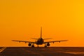 Silhouette of air plane landing at sunset with beautiful red sky in background. Evacuation Royalty Free Stock Photo