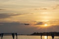 the silhouette of an airplane against the background of the sea, the beach, the mountains and the setting sun Royalty Free Stock Photo