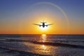 Silhouette of an airplane on the background of halo over the sea