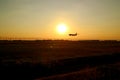 Silhouette of an airplane flying up against sunset sky Royalty Free Stock Photo