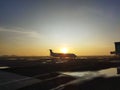 Silhouette of an airplane parked in the airport apron area at sunrise