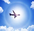 Silhouette of an airplane in the sky sun and halo in the clouds. Royalty Free Stock Photo