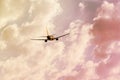 Silhouette of an airplane taking off high into the sky at sunset with a warm shade of clouds Royalty Free Stock Photo