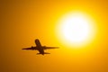 Silhouette of airplane taking off during sunset, flies near the disc of the sun. Royalty Free Stock Photo