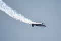 Silhouette of an airplane with trail of smoke behind against background of blue sky. Royalty Free Stock Photo