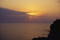 Silhouette alone lonely man are standing on hill against sunset purple orange sky with round sun over sea Royalty Free Stock Photo