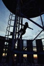 Silhouette of alpinist girl climbing to the top of building