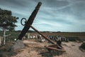 Silhouette of an anchor against a bright blue sky, symbolic of a memorial to lost sailors