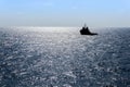 Silhouette of an anchor handling tug boat at oil field during sunrise