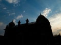 Silhouette of ancient structure, birds in sky and sunrays