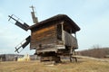 Silhouette ancient windmil rural landscape and church on backdrop. National Open Air Museum of Folk Architecture Pirogovo