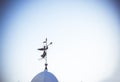 Silhouette of an angel. Weathervane on the dome of the temple against clean blue sky. The concept of peace and religion