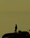 Silhouette of an angler on the rock