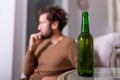 Silhouette of anonymous alcoholic person drinking behind bottle of alcohol. Man fighting with alcoholic habits, drink sitting on