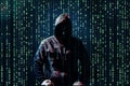 Silhouette of anonymous hacker and binary code on dark background. Cyber attack concept