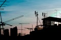 Silhouette antenna on building rooftop with sunset in urban or city area, in evening time. Royalty Free Stock Photo