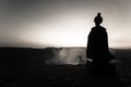 Silhouette of Arab man stands alone in the desert and watching the sunset with clouds of fog. Eastern Fairytale Royalty Free Stock Photo